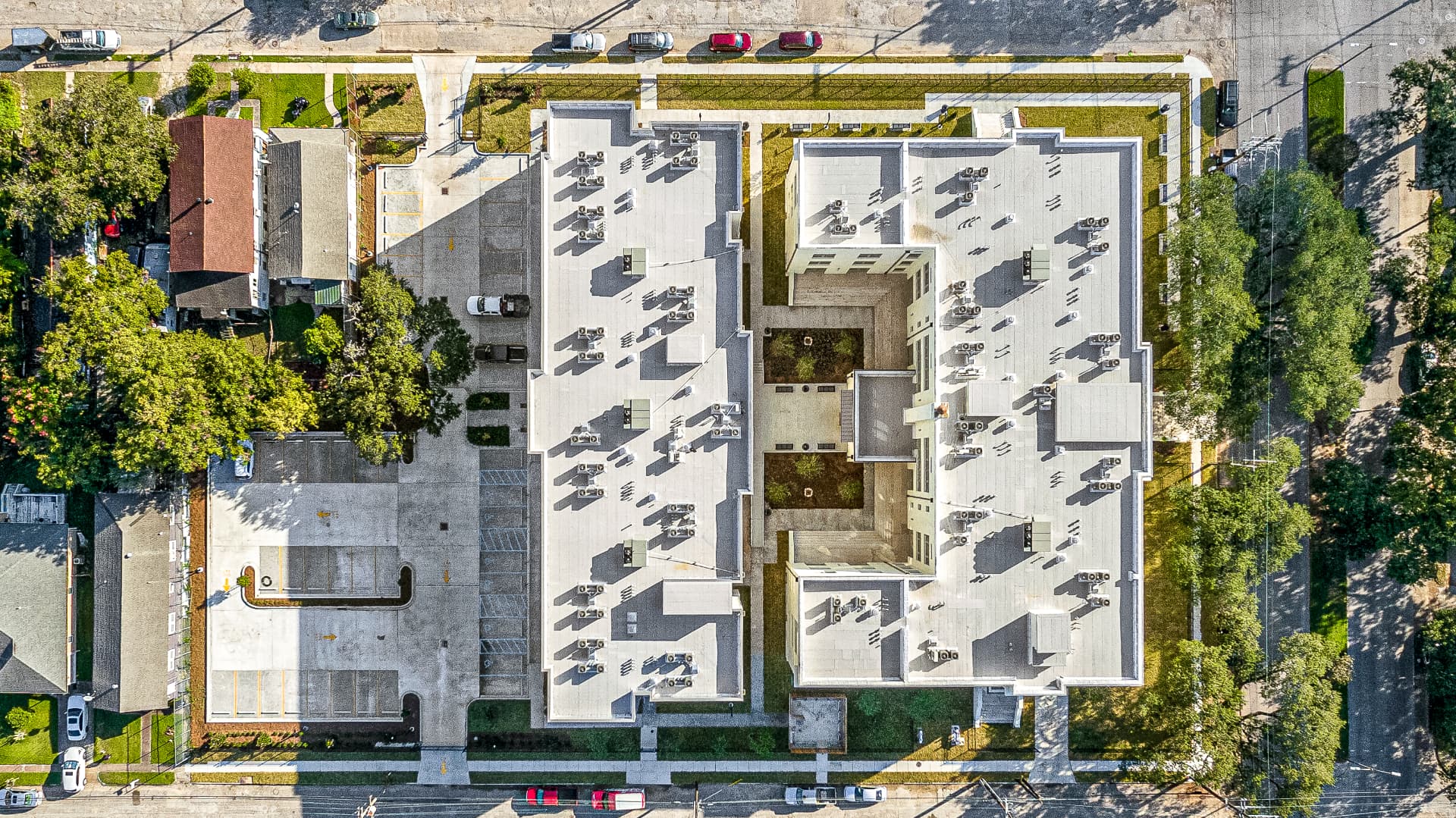 Aerial view of a newly renovated building complex with courtyards and parking