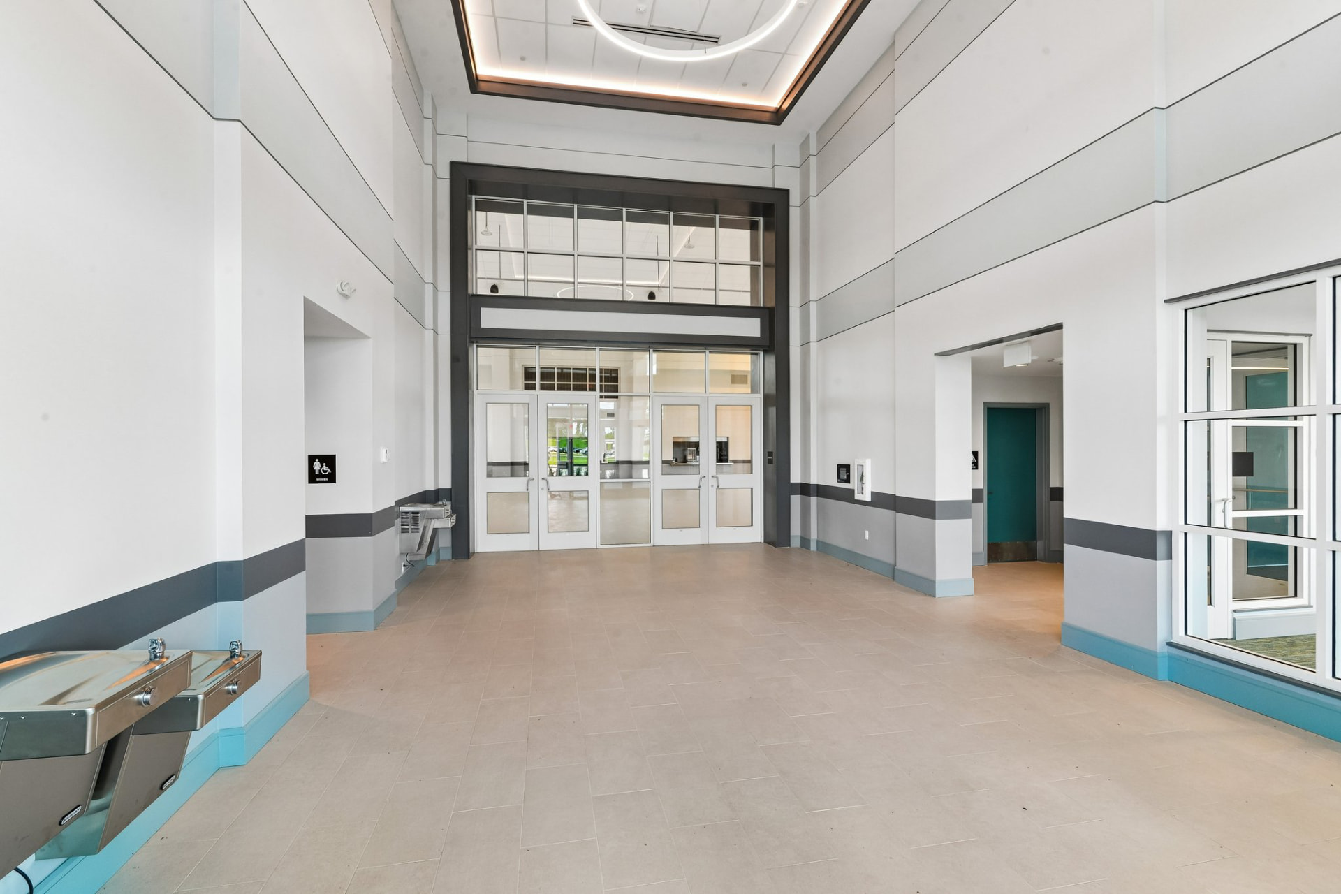 Two-story lobby of a finished institutional building with glazed entry