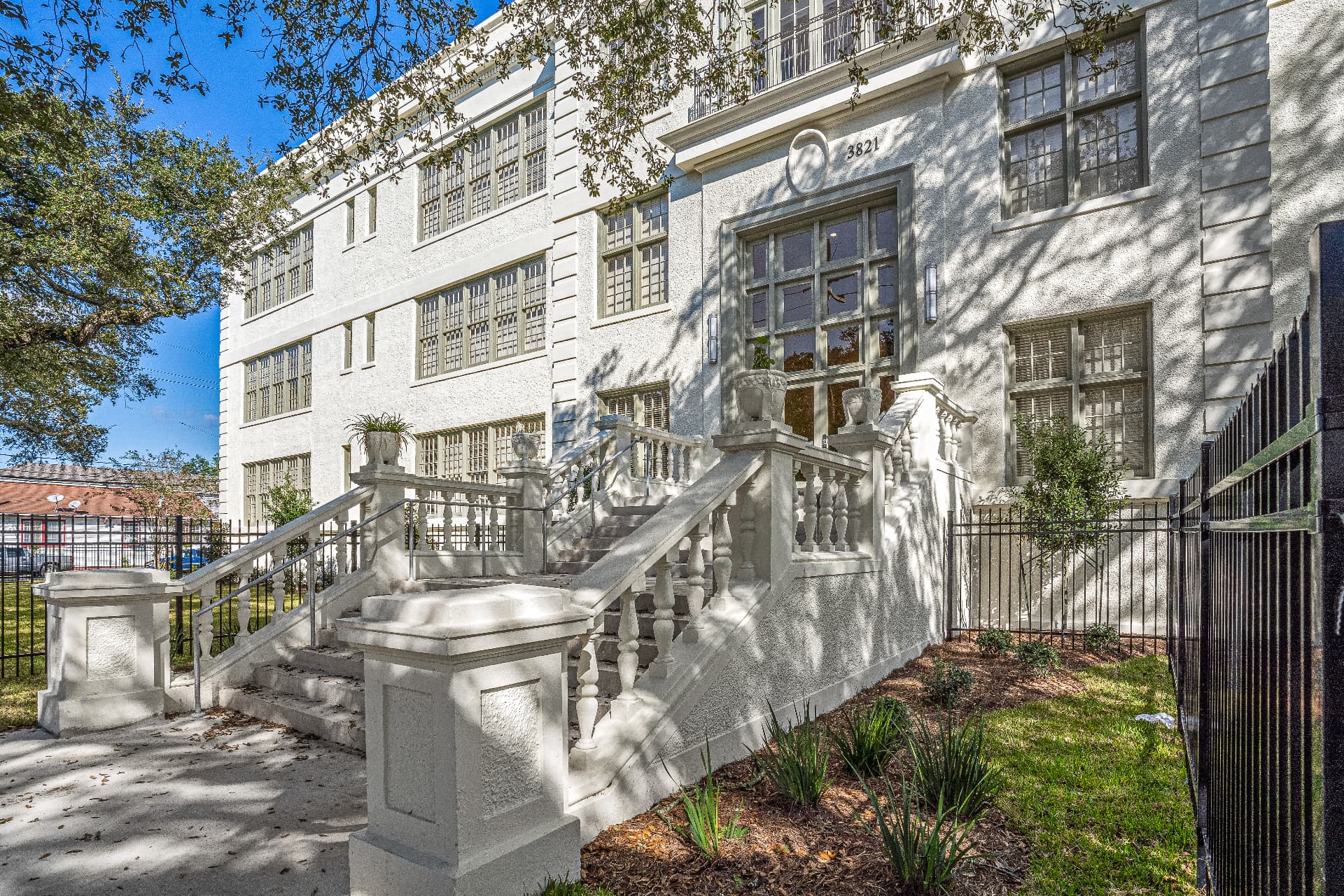 Restored entrance of a historic school building with grand stone stairs and balustrades