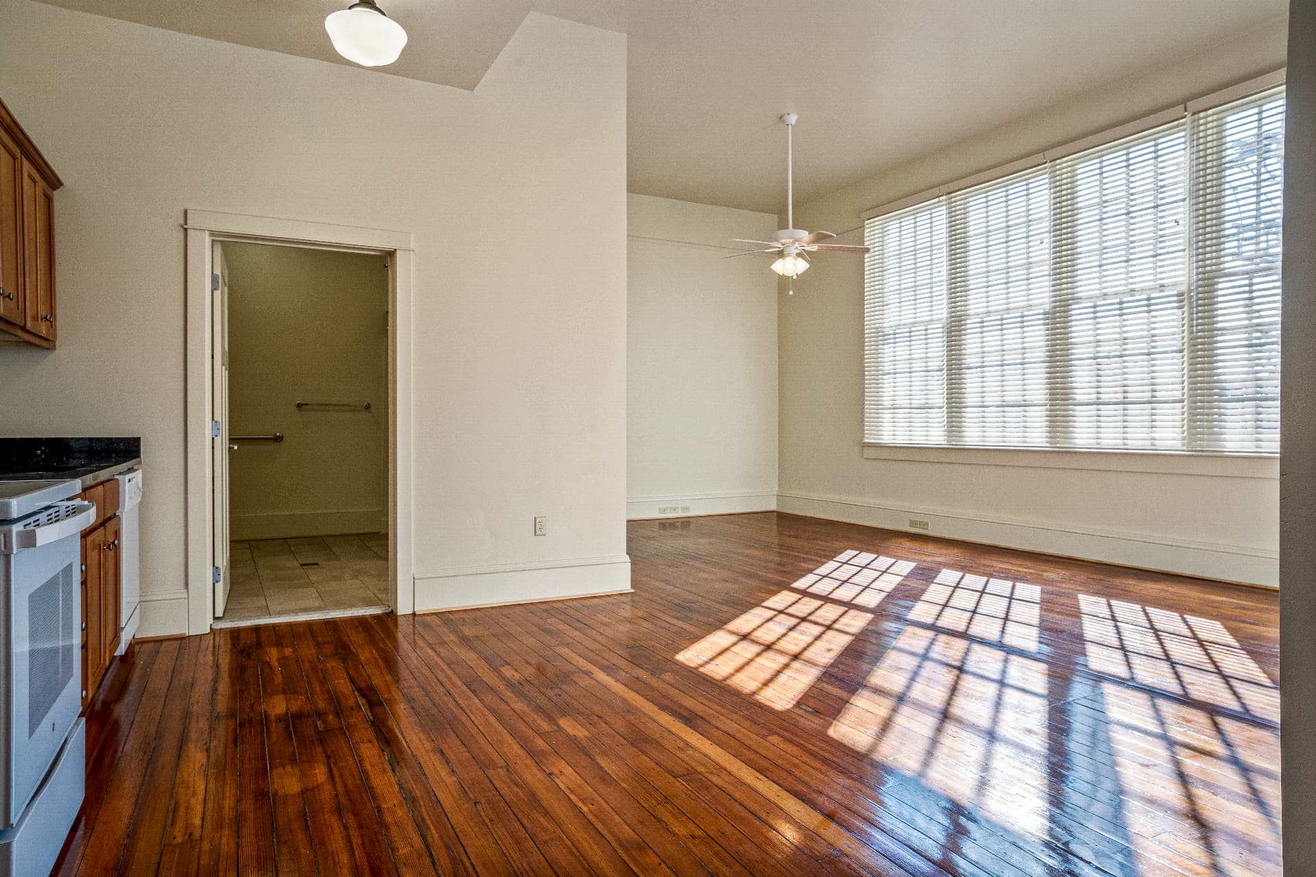 Renovated apartment living space with refinished hardwood floors and new kitchen