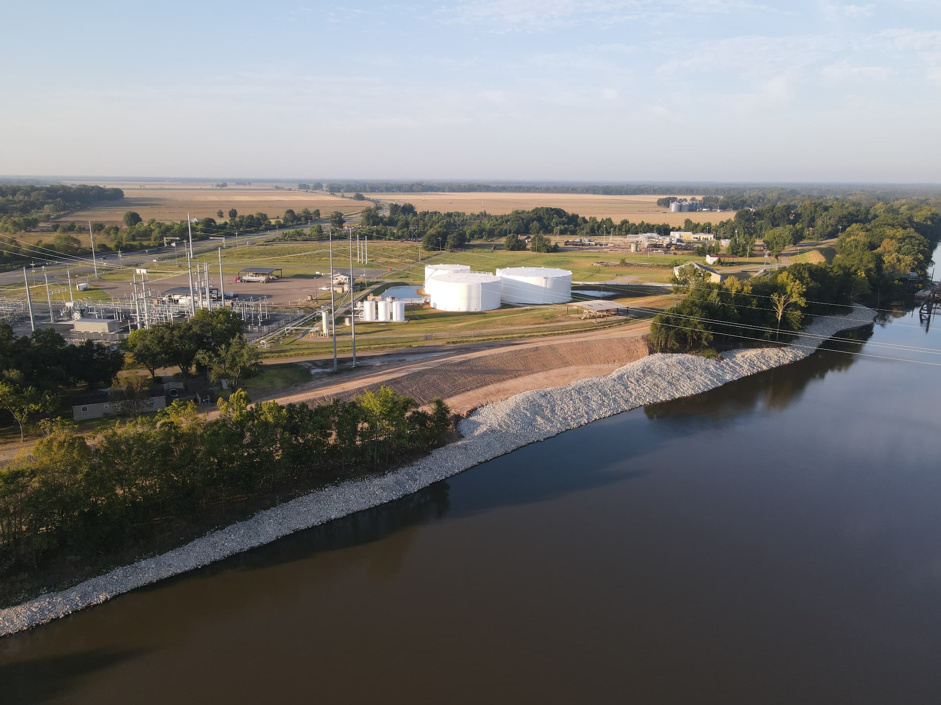 Aerial view of a riverside levee with newly placed rock revetment